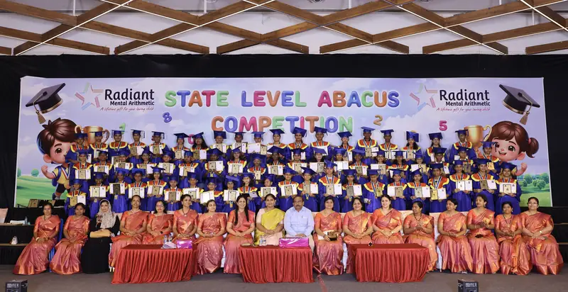 Radiant students seated together at a State Level Abacus Competition stage backdrop