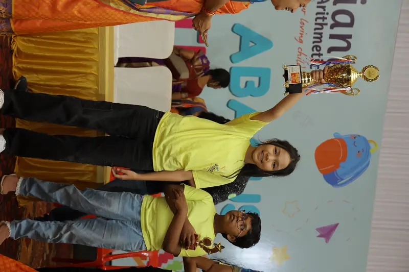 A Radiant student holding up a trophy and smiling after the results